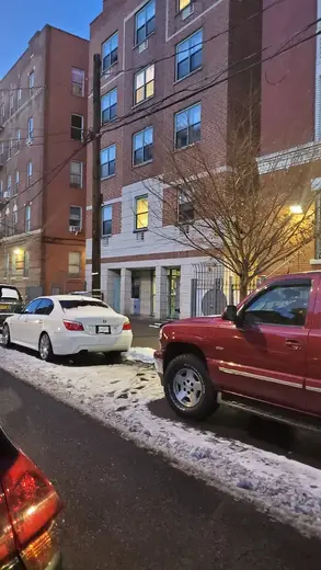 Exterior view of Casa Esperanza, a sober living home in Bronx, with parked cars and snow-covered street.